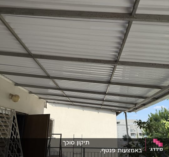 סככה מותקנת מעל מרפסת עם סולם בצד